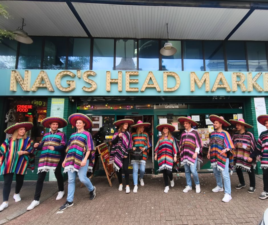 People in colourful ponchos outside Nag's Head Market celebrating Mexican food and tacos in North London